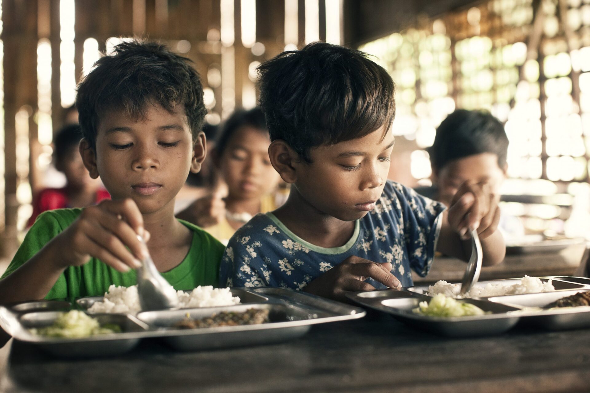 Cambodja. To drenge spiser frokost, som deres mor har været med til at lave. De er en del af SOS Børnebyernes familieprogram, hvor mødrene blandt andet lærer at lave god og nærende mad til deres børn.