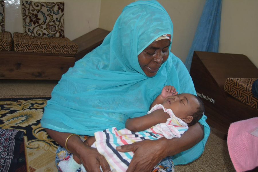 lille Kiti fra Zanzibar med sin SOS-mor. SOS-mor Mwanahamis sidder med lille Kiti i armen. Her har Kiti kun været i børnebyen et par måneder.