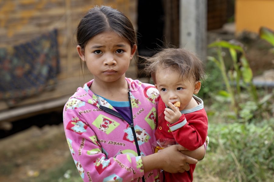 Stor pige med barn på armen. Laos.