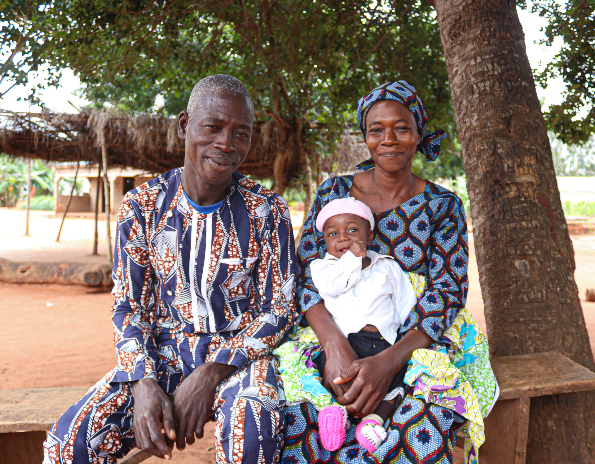 Mor, far og barn under et træ. Togo. Lægehjælp og sundhedspleje, SOS Børnebyerne mobilt hold jordemødre, som bringer sundhedsplejen ud på landet.