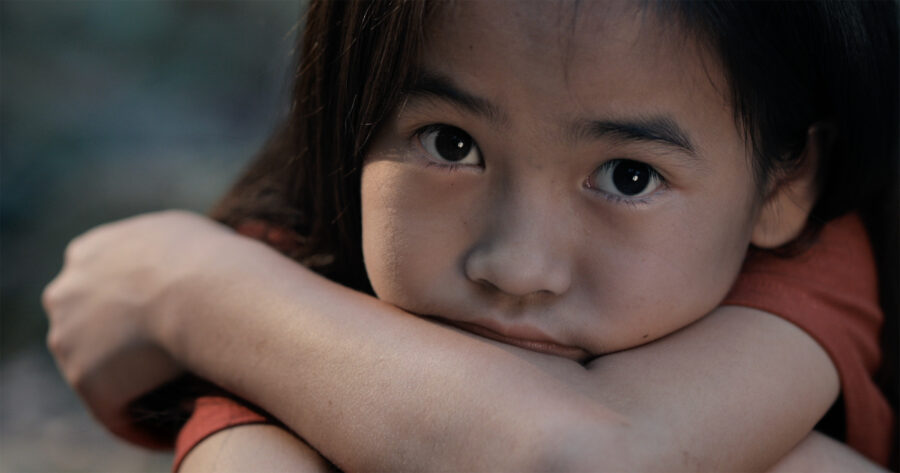 Pige der sidder med armene over kors