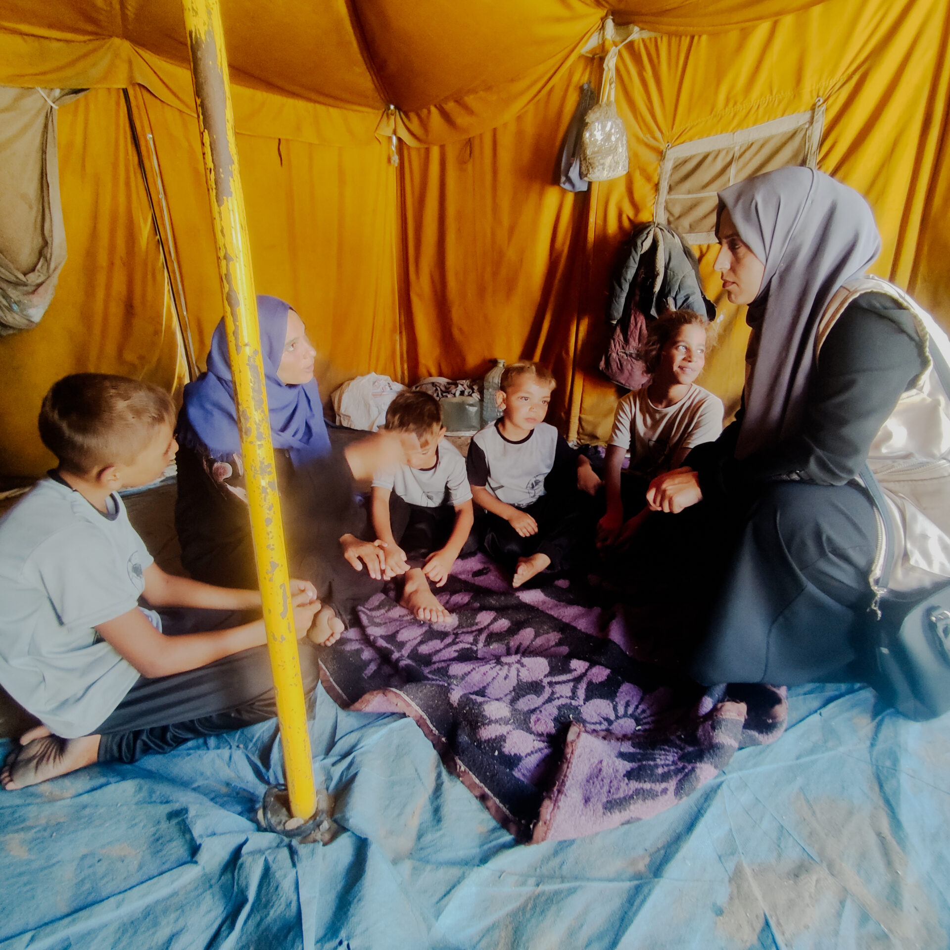 SOS medarbejder taler med familie i Gaza teltlejr