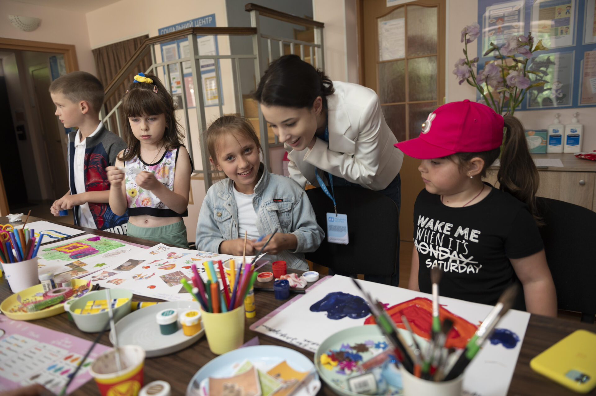 En gruppe børn laver kreative aktiviteter sammen med en voksen