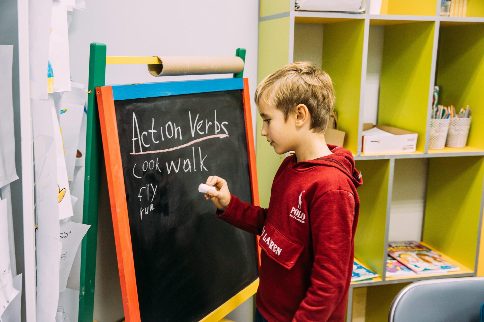 Dreng står ved tavle og skriver engelske ord
