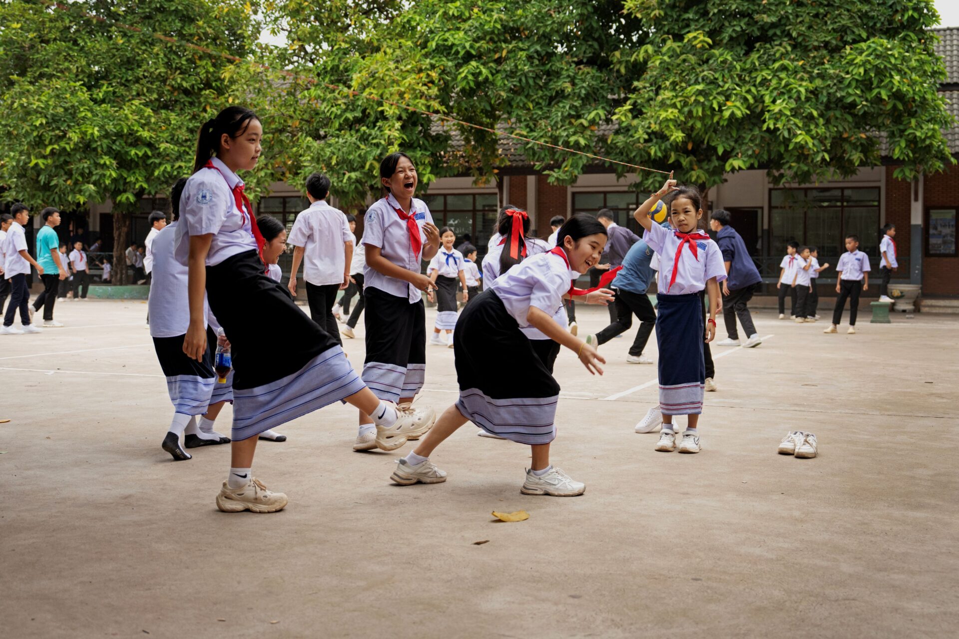 Piger leger i skolegården, skole i Laos